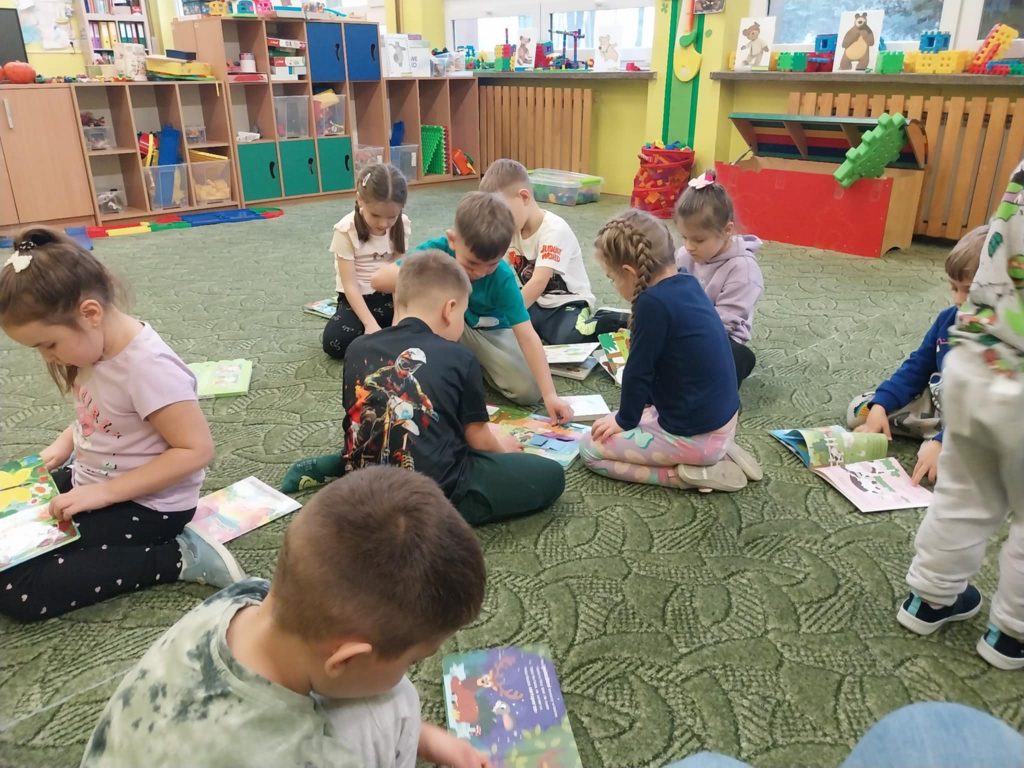 zdjęcie przedstawia dzieci przy książkach