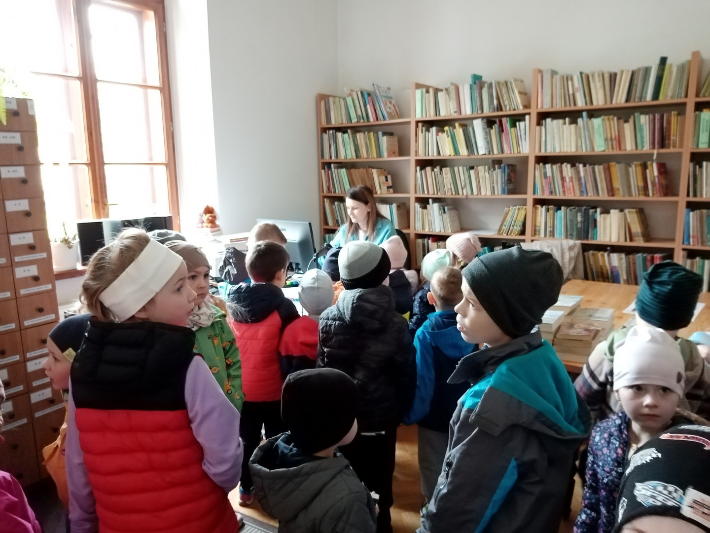 zdjęcie przedstawia dzieci z ochronki z wizytą w bibliotece w Szczurowej